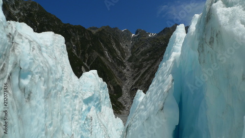 Ice of the Franz Josef glacier in New Zealand meets temperate rainforest