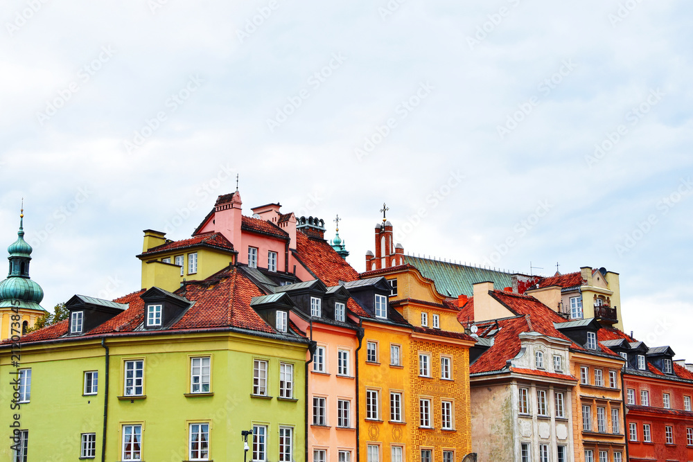 Old town buildings with bright colorful decorative facades on blue sky background  in summer morning in poland with copy space for text.