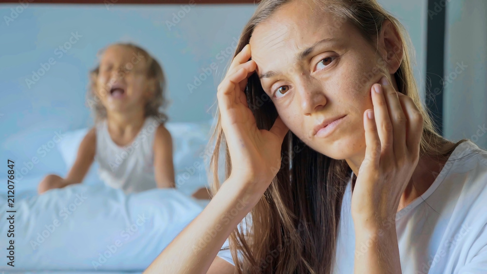 Upset mother with angry little child screaming pillow on the background Upset mother with angry little child screaming pillow on the background