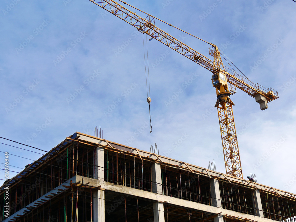 Crane. Construction crane near concrete building. Construction site background