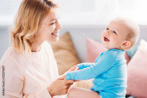 beautiful mother having fun with laughing child at home