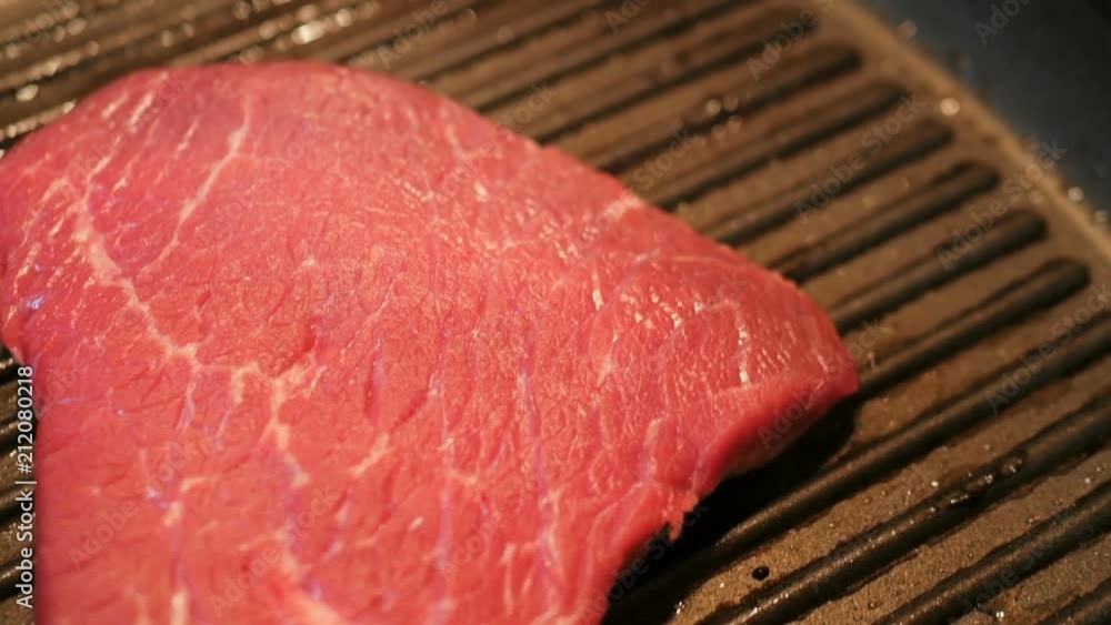 Cooking raw meat in slow motion. Pieces of meat are turned in a frying