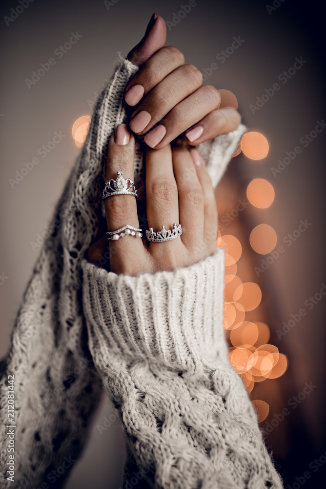 Hands with silver rings on golden bokeh lights background - obrazy, fototapety, plakaty 