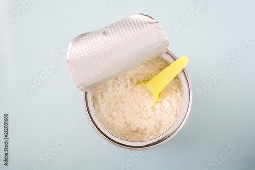 powder milk in the bottle on gray background. Top view