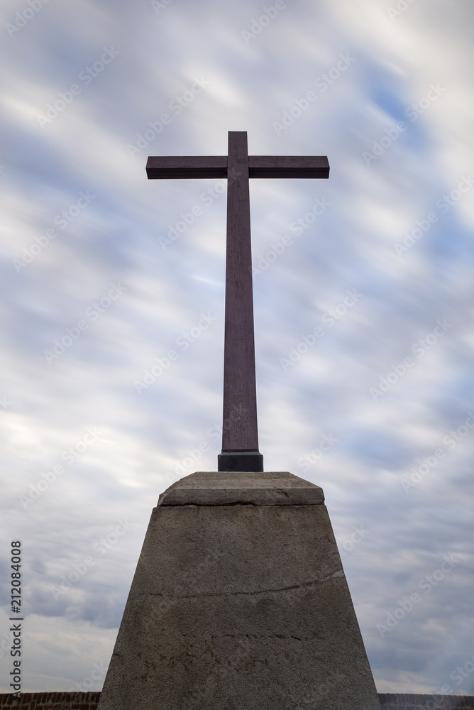 cross on monument and smoothed clouds in sky
