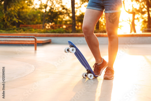 Croped image of a young girl standing with skateboard