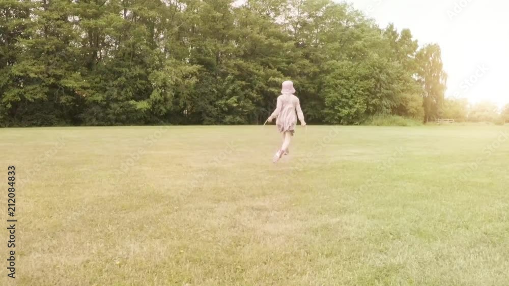 Little girl jumping rope on green meadow. Summer lifestyle moment of a happy childhood. Little girl jumping rope on green meadow. Summer lifestyle moment of a happy childhood.