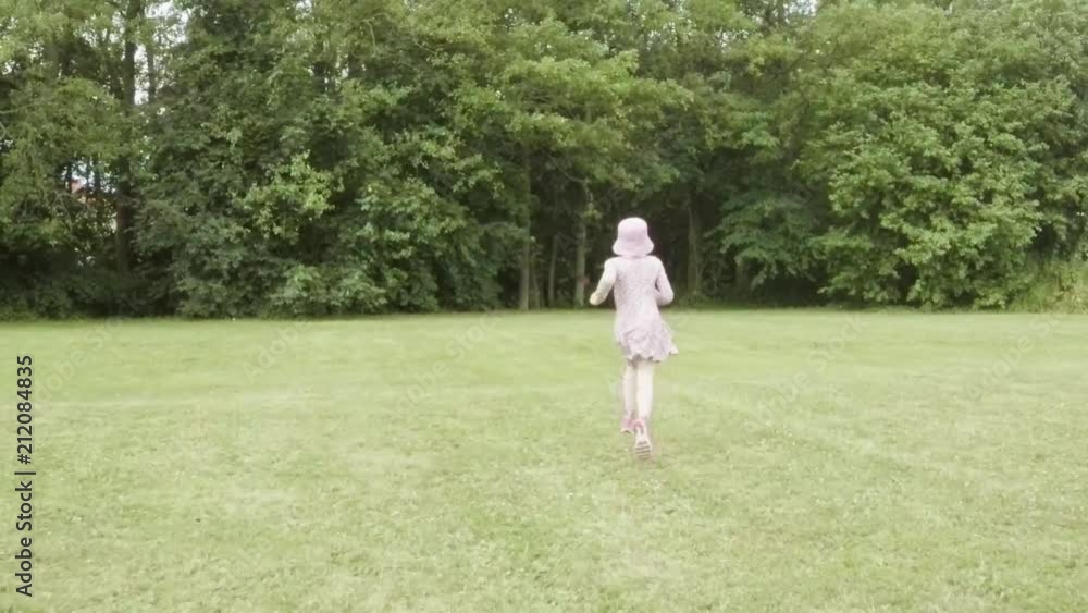 Little girl running on green meadow. Summer lifestyle moment of a happy childhood. Little girl running on green meadow. Summer lifestyle moment of a happy childhood.