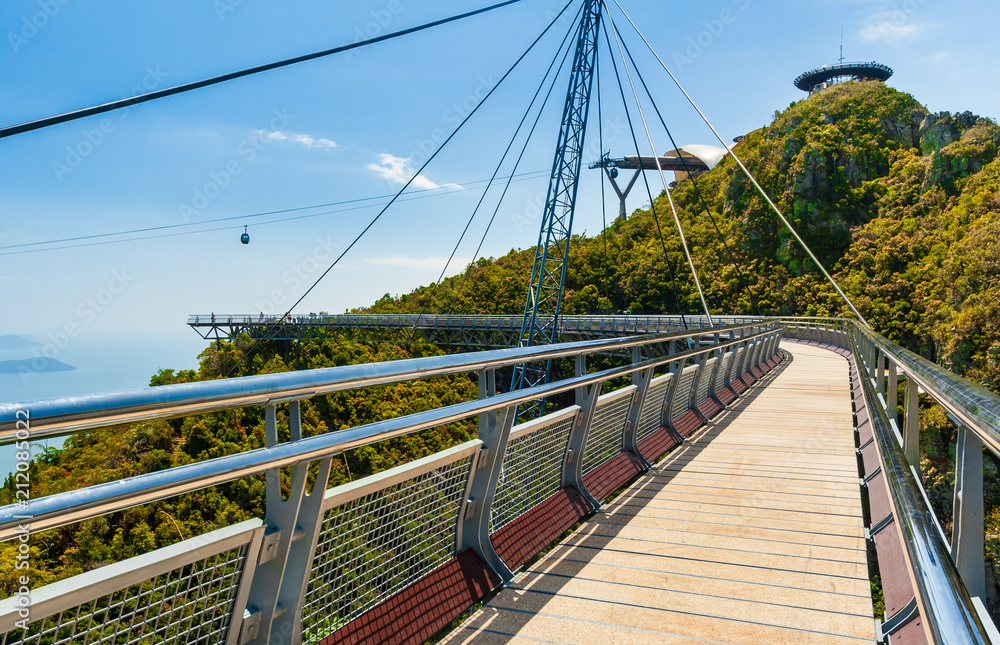 A stroll on the curved pedestrian suspended bridge, the single-pylon Langkawi Sky Bridge, towards the triangular viewing platform from a tourist's perspective in Langkawi, Malaysia.