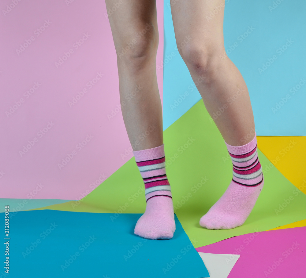 designer claw protest Naked female feet in socks posing on a multi-colored paper background.  Stock Photo | Adobe Stock