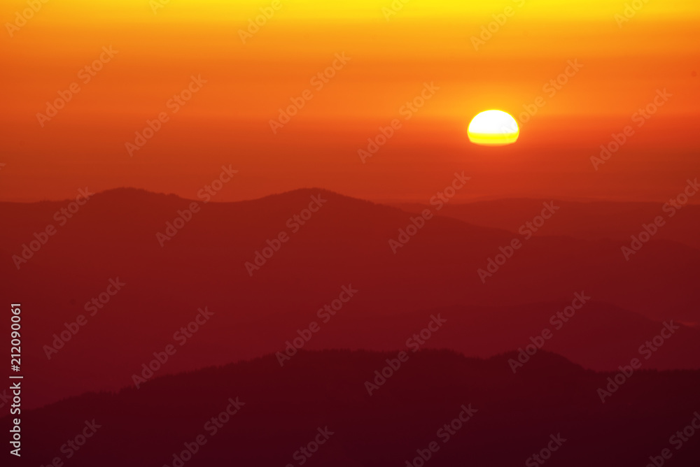 Beautiful golden sunrise. Red sky with sun and mountain range, natural outdoor travel background Beautiful golden sunrise. Red sky with sun and mountain range, natural outdoor travel background
