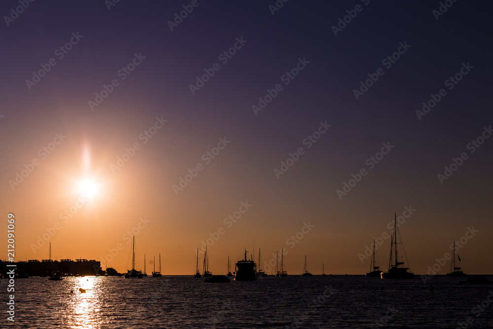 beautiful silhouette of the boats in the port at sunset in Ibiza. Holidays and summer concept