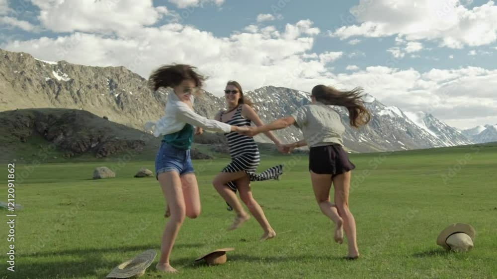 Trendy Hipster Girls having fun outdoor. Three cute women are whirling on green grass. Best friends. Trendy Hipster Girls having fun outdoor. Three cute women are whirling on green grass. Best friends.
