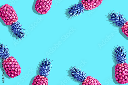 Pink painted pineapples on a vivid blue background. Minimal summer concept.