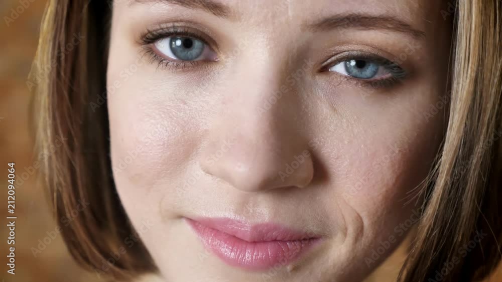 Face of young attractive girl is smiling, watching at camera, brick background Face of young attractive girl is smiling, watching at camera, brick background