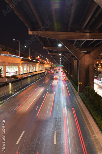 Fotografie The light motion of car on road under tollway in the night at Bangkok, Thailand