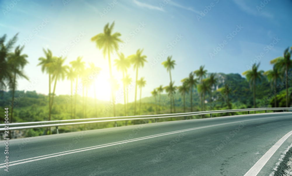 Summer background of road with palms and sunset time Summer background of road with palms and sunset time