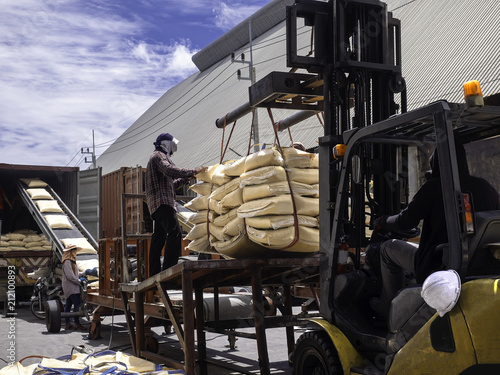 Sugar in bags are staffing in container for export by conveyor process. photo