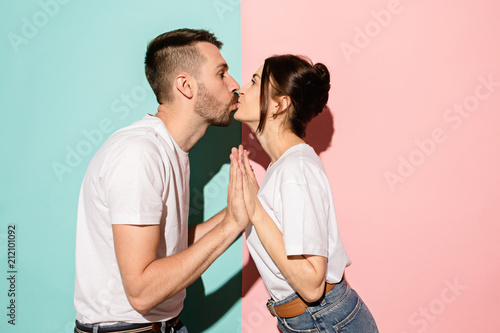 A view of a loving couple kissing on blue and pink background