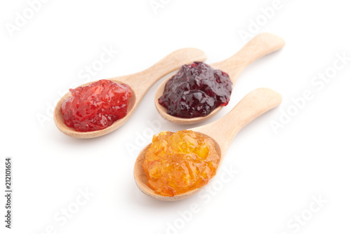 Strawberry, orange and blueberries jam with wooden spoon on a white background