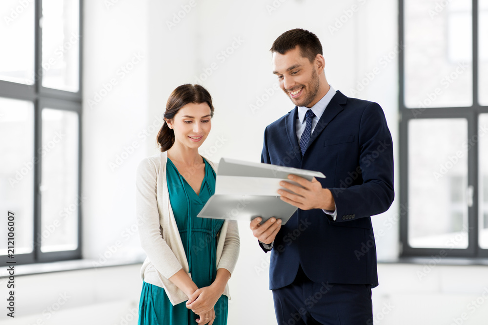 real estate business, sale and people concept - happy smiling realtor with folder showing documents to female customer at new office room