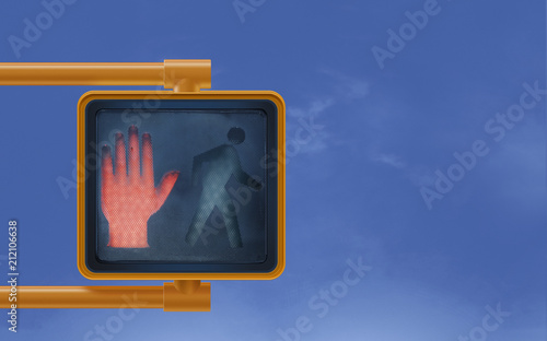 Don't  walk red hand stop street signal for pedestrians on blue shy 