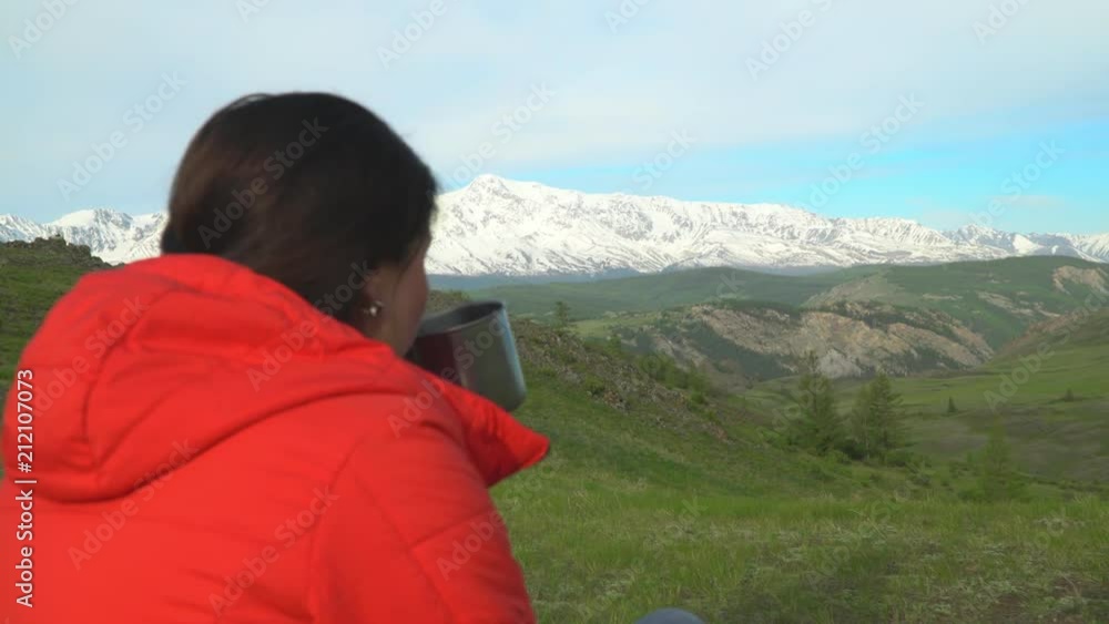 The woman the traveler has tea. View of snow mountains. The woman the traveler has tea. View of snow mountains.