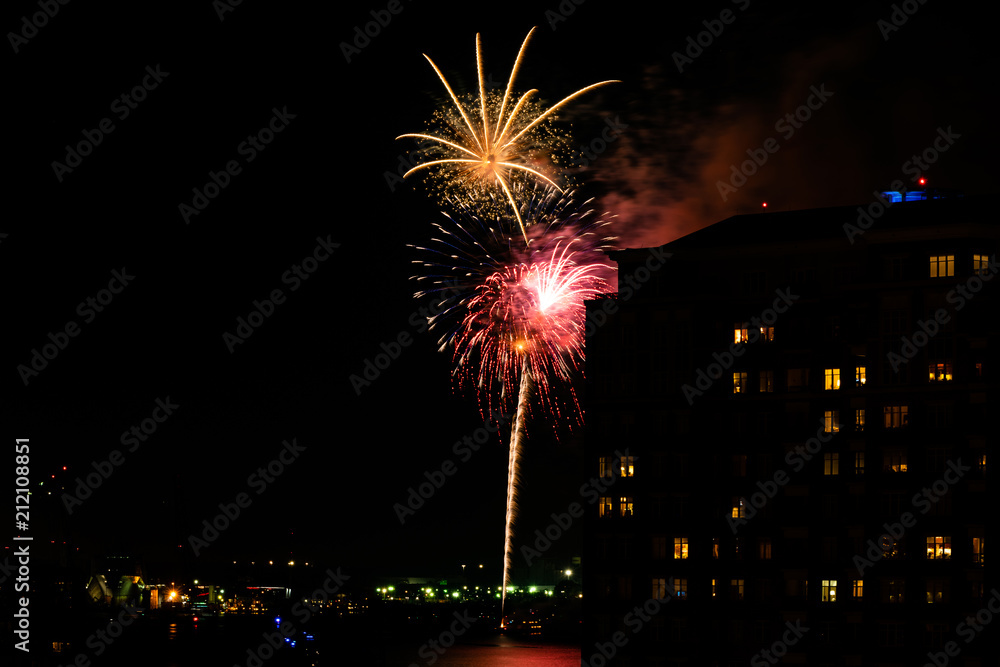 A Fourth of July fireworks display explodes over the waterfront in the city center of Norfolk Virginia, in the context of buildings, apartments, and dwellings A Fourth of July fireworks display explodes over the waterfront in the city center of Norfolk Virginia, in the context of buildings, apartments, and dwellings