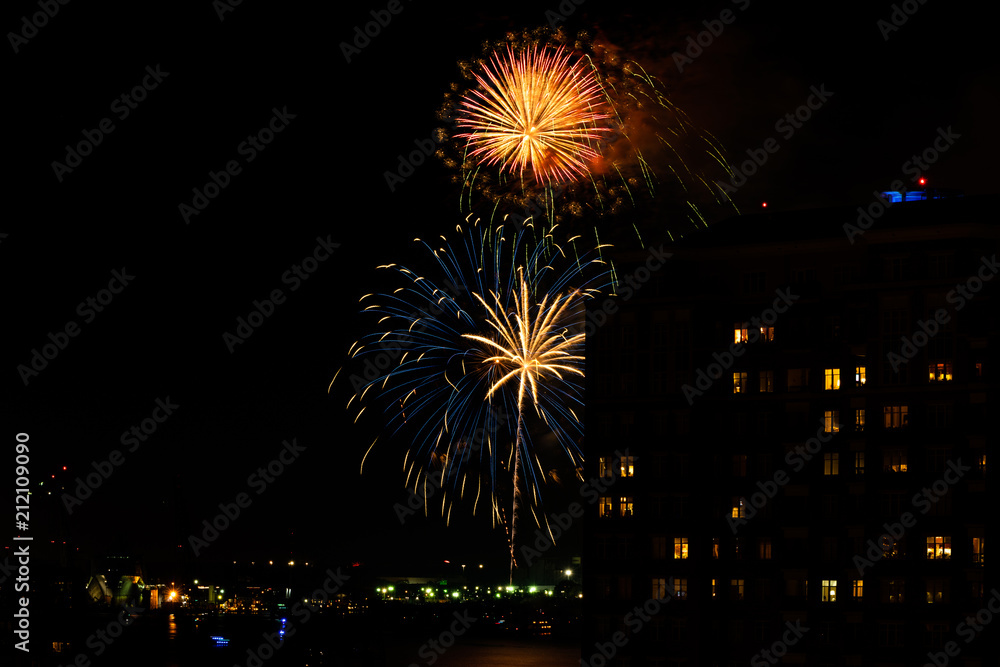 A Fourth of July fireworks display explodes over the waterfront in the city center of Norfolk Virginia, in the context of buildings, apartments, and dwellings A Fourth of July fireworks display explodes over the waterfront in the city center of Norfolk Virginia, in the context of buildings, apartments, and dwellings
