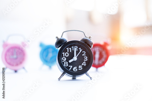 IN selective focus of black alarm clock,blurry light design background