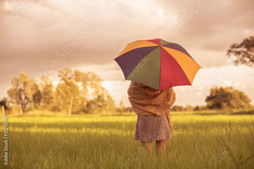 Woman holding an umbrella in a meadow mood lonely winter.