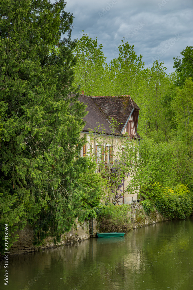 Riverside house and boat in the picturesque town of Noyers sur Serein, Burgundy, France