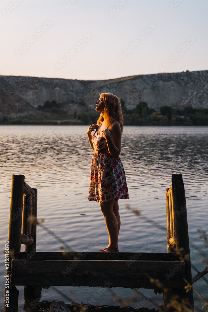 Woman standing on sunken pier in sunlight Woman standing on sunken pier in sunlight