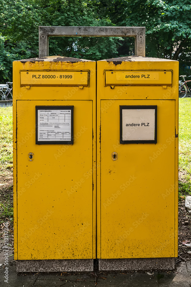 Munich, Germany - June, 2018: Typical German yellow letterbox in Munich with two slots divided by postal code (for local and for global deliveries) Munich, Germany - June, 2018: Typical German yellow letterbox in Munich with two slots divided by postal code (for local and for global deliveries)