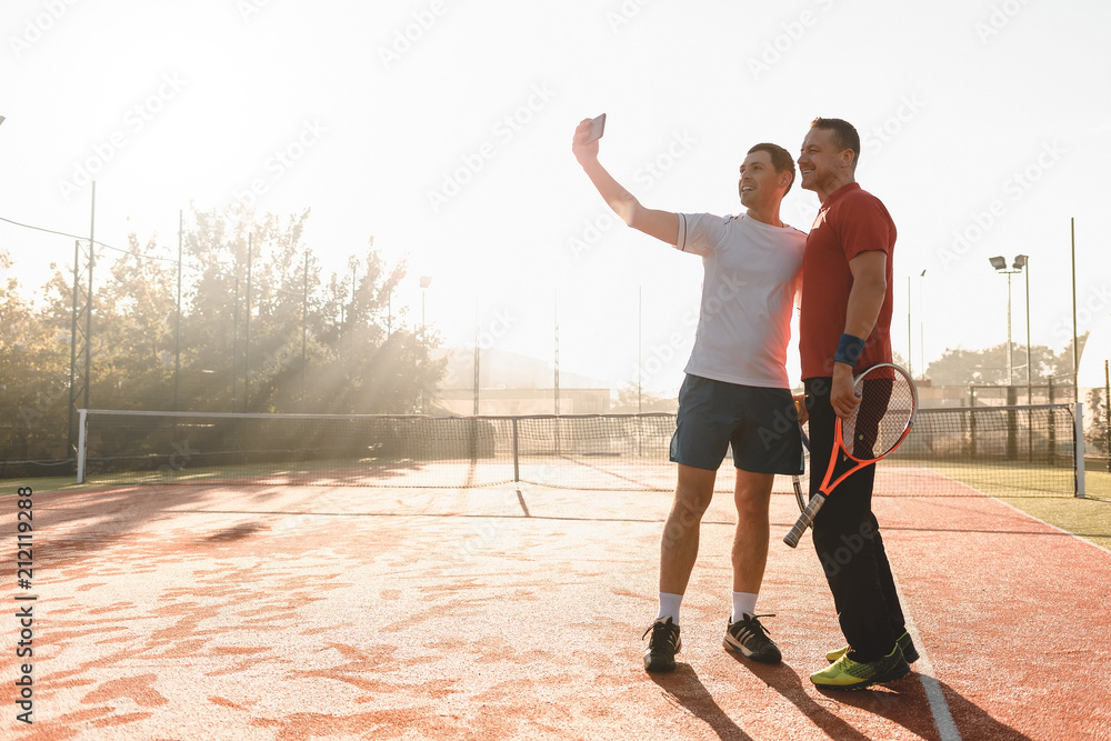 Tennis players taking selfie after match in the morning sunlight
