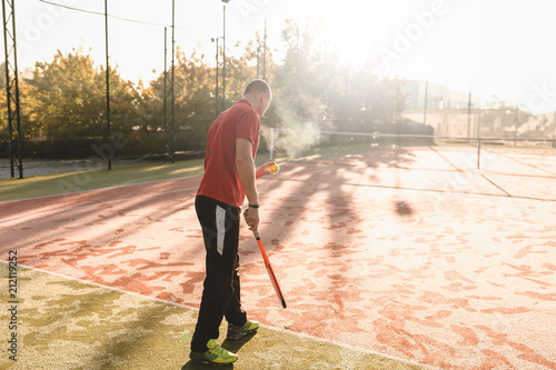 Young man is playing tennis on fresh sunny morning