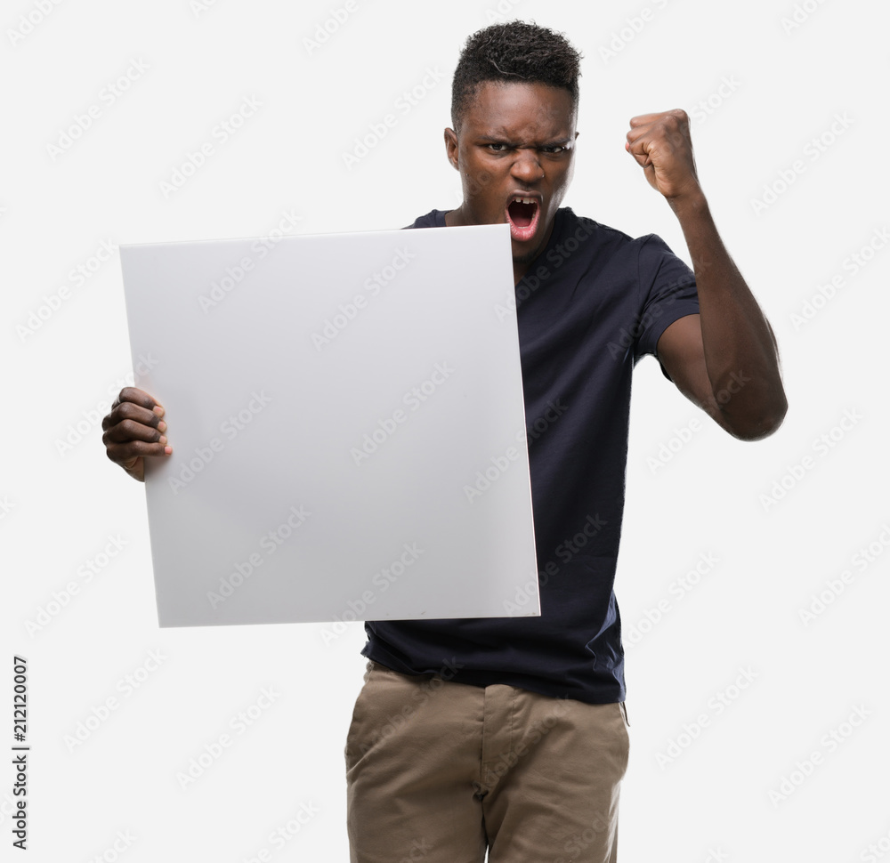 Young african american man holding a banner annoyed and frustrated shouting with anger, crazy and yelling with raised hand, anger concept Young african american man holding a banner annoyed and frustrated shouting with anger, crazy and yelling with raised hand, anger concept