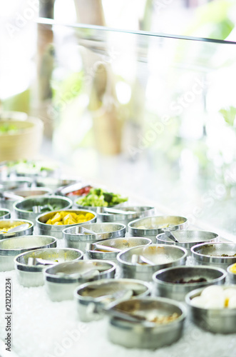 bowls of mixed fresh organic vegetables in salad bar display