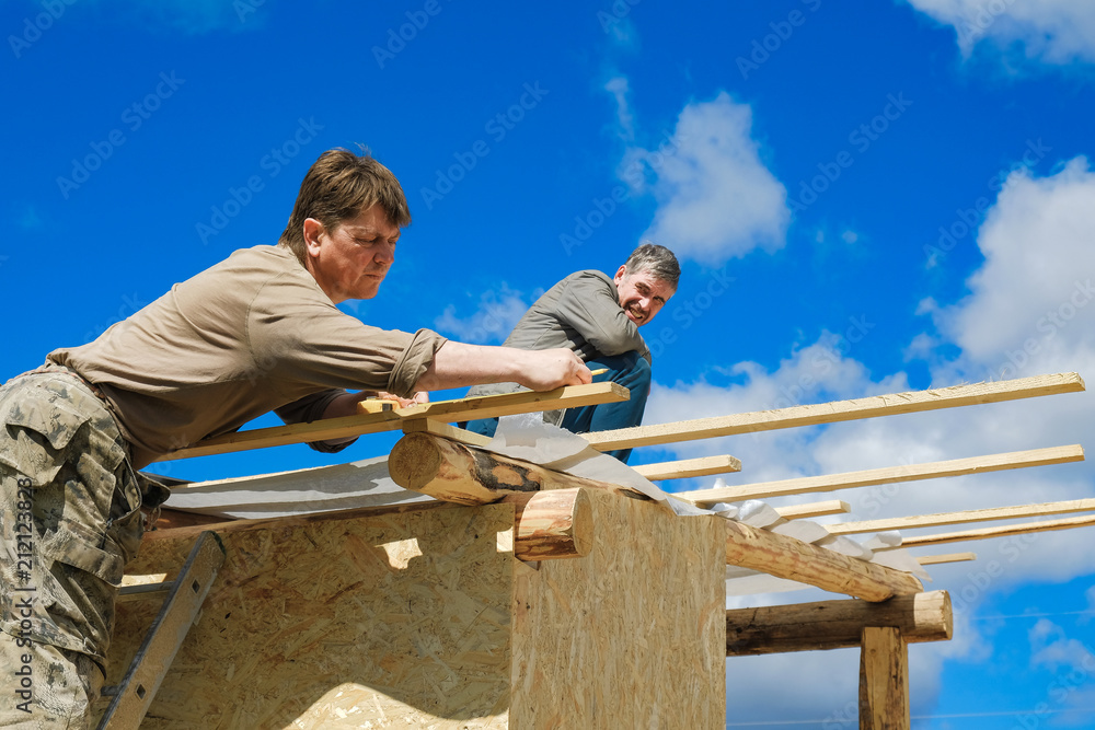 workers make a roof in a country house workers make a roof in a country house