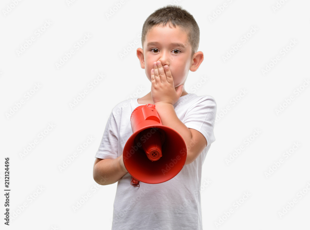 Dark haired little child holding megaphone cover mouth with hand shocked with shame for mistake, expression of fear, scared in silence, secret concept Dark haired little child holding megaphone cover mouth with hand shocked with shame for mistake, expression of fear, scared in silence, secret concept