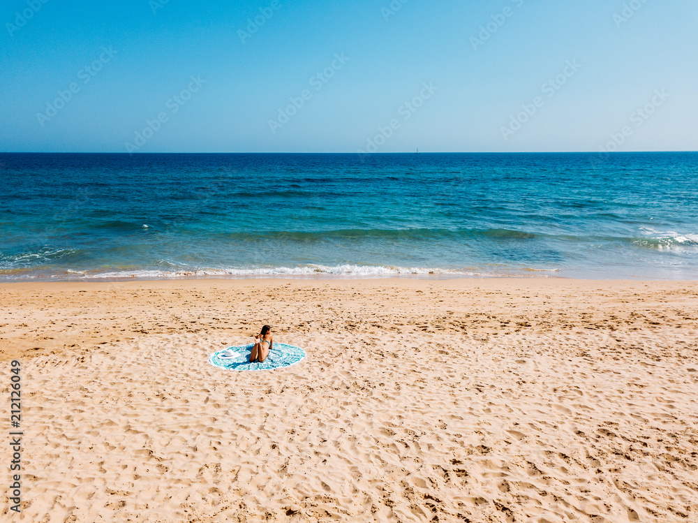 Top Aerial Drone View Of Woman In Swimsuit Bikini Relaxing And Sunbathing On Round Turquoise Beach Towel Near The Ocean Top Aerial Drone View Of Woman In Swimsuit Bikini Relaxing And Sunbathing On Round Turquoise Beach Towel Near The Ocean