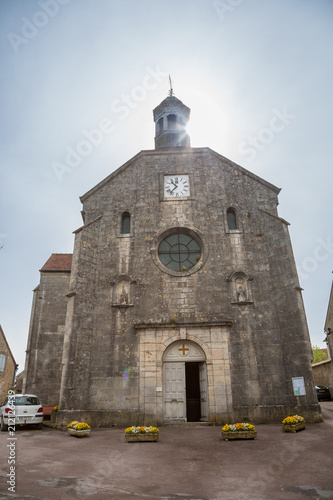 The sun behind the church in the picturesque town of Flavigny sur Ozerain, Burgundy, France photo