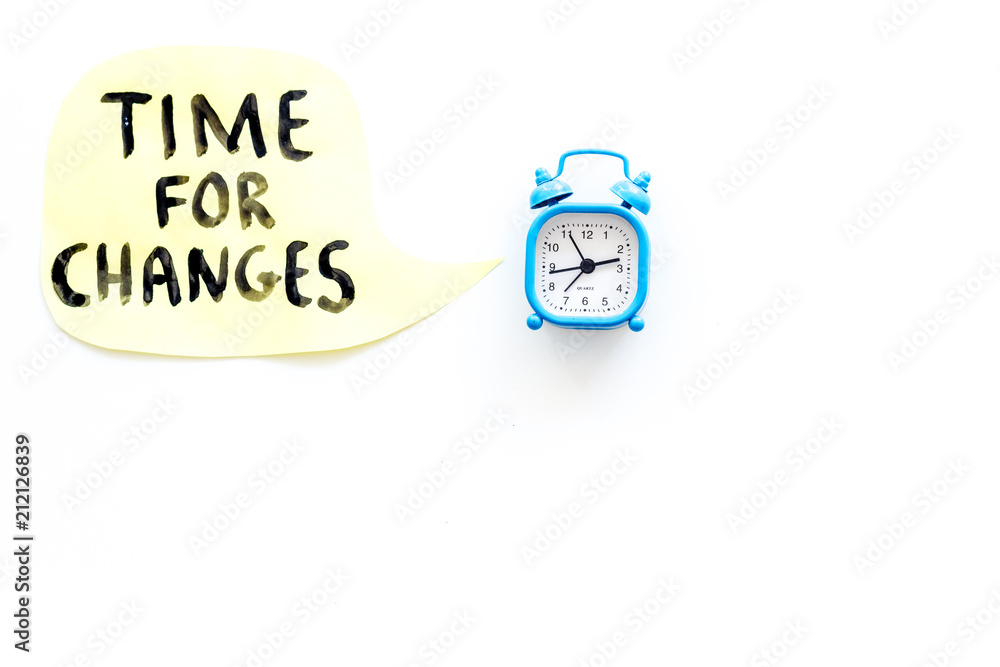 Time for changes hand lettering near alarm clock on white background top view copy space