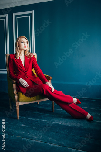  young woman in a red suit is sitting in a yellow armor with blue embroidered blue walls