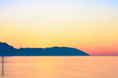 Red sunset over Greek islands in calm sea 