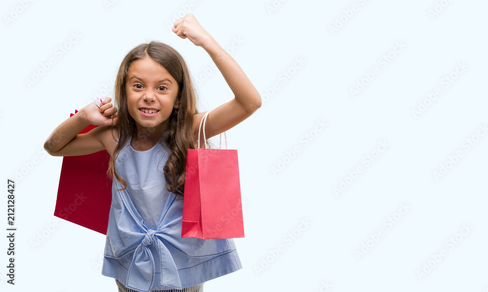 Brunette hispanic girl holding shopping bags annoyed and frustrated shouting with anger, crazy and yelling with raised hand, anger concept Brunette hispanic girl holding shopping bags annoyed and frustrated shouting with anger, crazy and yelling with raised hand, anger concept