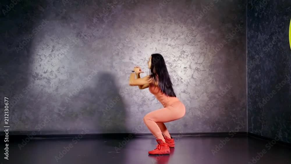 girl athlete performs an exercise to strengthen leg muscles deep squats with jumping up girl athlete performs an exercise to strengthen leg muscles deep squats with jumping up