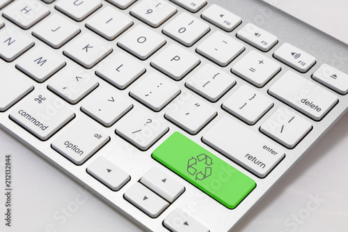 White keyboard with a green "recycle" symbol key.