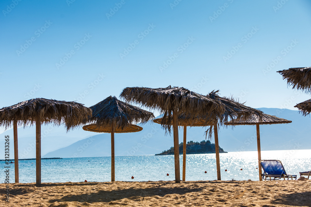 Sun parasols and deck chairs on beach