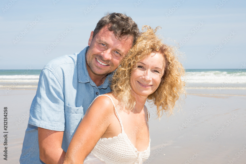 senior woman with handsome man hug on vacation beach